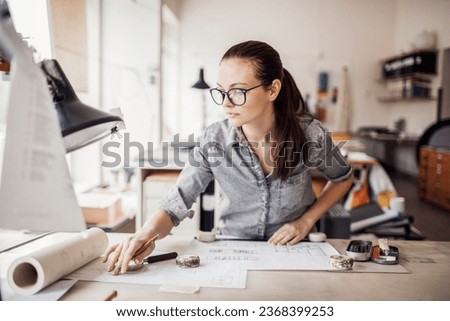 Young female architect working on building designs in the office