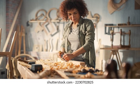 Young Female Artisan Carpenter Using Hand Plane to Shape a Wood Bar. Beautiful Artist Working on a Project in a Woodworking Workshop. - Powered by Shutterstock