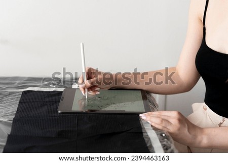 a young female artist designing new tattoo sketch on a tablet