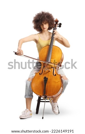 Young female artist sitting and playing a cello isolated on white background