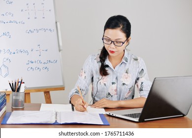 Young Female Asian Science Teacher In Glasses Filling Documents And Making Plan On Online Lesson