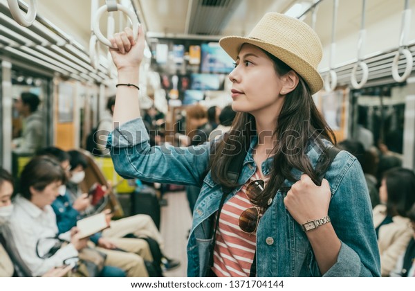 지하철에서 손잡이를 잡고 있는 젊은 아시아 스톡 사진 지금 편집