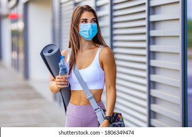 Young Female Athlete With Face Mask For Protecting Against Covid-19 Contagion Getting Ready For Urban Running And Fitness Workout. Motivated Woman Training Outside Under Coronavirus Health Crisis.