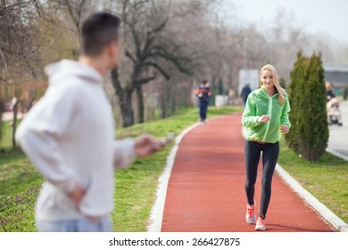 Young Female Athlete Running.Unrecognizable Sport Instructor Looking At His Student And Measuring Her Results