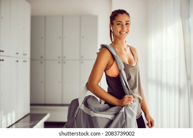 Young Female Athlete With Sports Bag Standing In Dressing Room In A Gym And Looking At Camera. Copy Space.