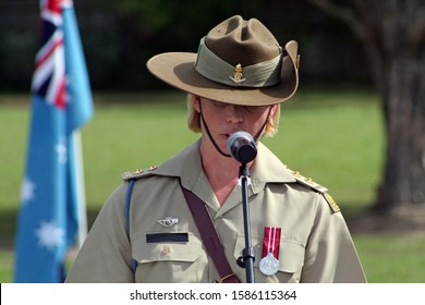 Young Female Australian Army Officer (soldier) Wearing Medal And Iconic Slouch Hat Gives Emotional Speech During ANZAC Rememberance Service In Front Of Australian Flags On The Gold Coast, Australia.