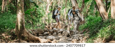 Young female backpacker group traveling in wild forest, Attractive girl traveler look around and explore while walk in nature wood with happiness and fun during holiday vacation trip.