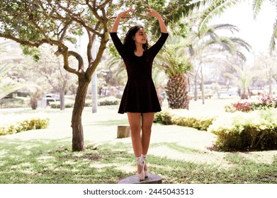 Young female ballet dancer perfects her stance amid serene park surroundings - Powered by Shutterstock