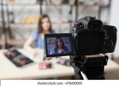 Young female beauty blogger on camera screen. Beautiful girl recording video at studio. Fashion, makeup, technology concept - Powered by Shutterstock