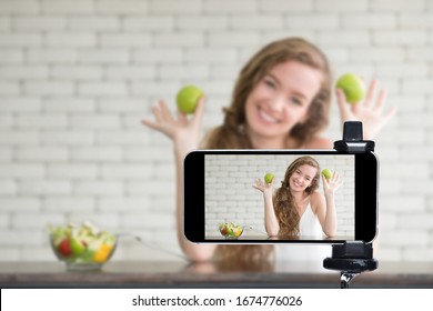 Young Female Blogger And Vlogger And Online Influencer Live Streaming A Cooking Show On Social Media Using A Smartphone