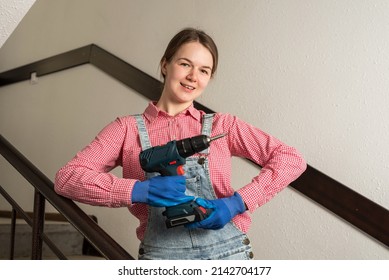 Young Female Blue Collar Manual Labour Worker Holds Cordless Screwdriver