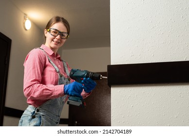 Young Female Blue Collar Manual Labour Worker Uses Cordless Screwdriver