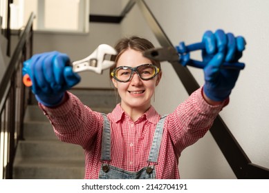 Young Female Blue Collar Manual Labour Worker Holds Pliers And Wrench 