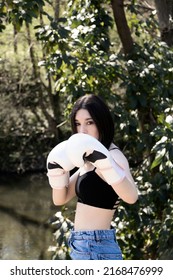 Young Female Boxer With White Gloves In A Park