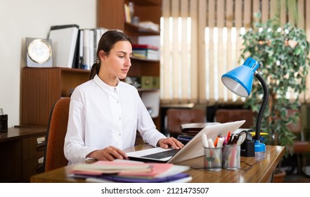 Young Female Business Manager Working In The Office Of A Large Company Is Typing Important Documents On A Computer ..while Sitting At Her Workplace