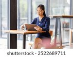 Young Female business person using digital tablet and laptop or remote working at coffee shop