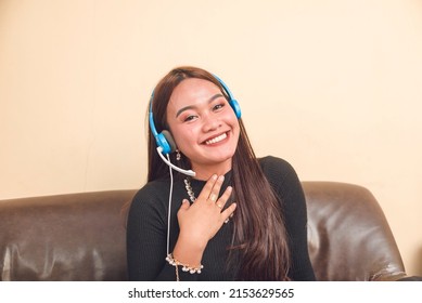A young female call center agent working remotely at home. Motivated and smiling. First job and telework concept. - Shutterstock ID 2153629565