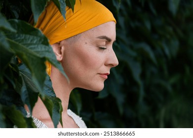 Young female cancer patient wearing headscarf closed eyes side view garden portrait. Mental wellbeing, emotional support, contemplation and mindfulness during cancer illness. - Powered by Shutterstock