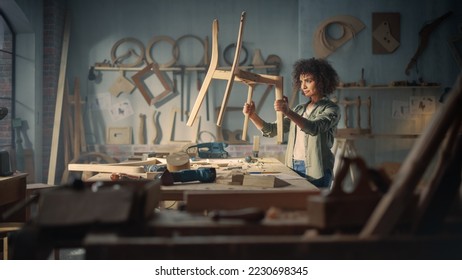 Young Female Carpenter Reading Blueprint, Making Notes, Starting to Assemble Parts of a Wooden Chair. Stylish African American Furniture Designer Working in a Studio in Loft with Tools on Walls.