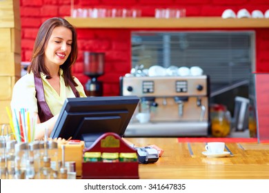 Young Female Cashier Operating At The Cash Desk In Cafe