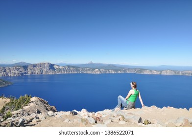 Young female Caucasian hiker in green tank top overlooking Crater Lake National Park, Oregon, USA - Powered by Shutterstock