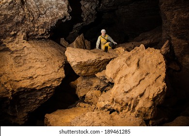 Young female caver exploring the cave. Mlynky Cave, Ukraine