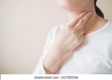 Young female checking pulse on her neck for an easy way to monitor heart rate at home. Health care and medical concept. Close up. Copy space.