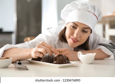 Young Female Chef Cooking Tasty Dessert In Kitchen