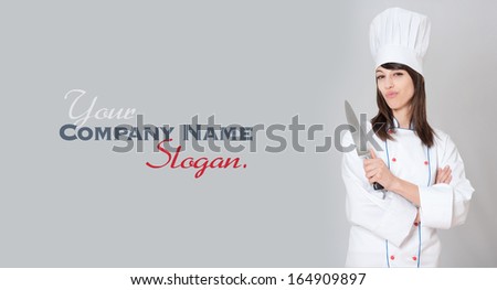  Young female chef holding a carving knife with a funny expression 