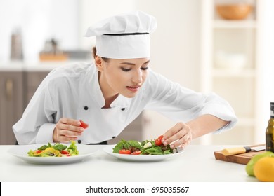 Young Female Chef With Tasty Dishes In Kitchen