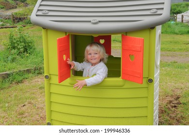 Young Female Child In A Playhouse On A Farm In Devon.