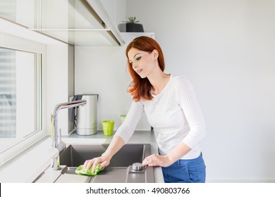 Young Female Cleaning Kitchen