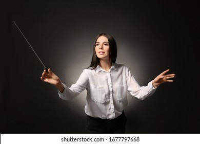 Young Female Conductor On Dark Background