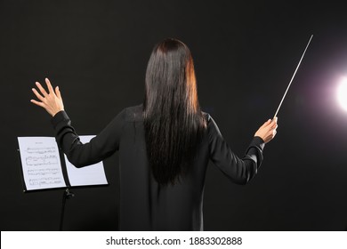 Young Female Conductor On Dark Background