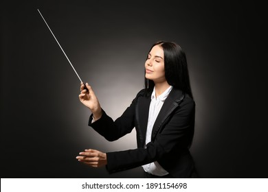 Young Female Conductor On Dark Background