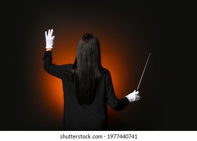 Young Female Conductor On Dark Background