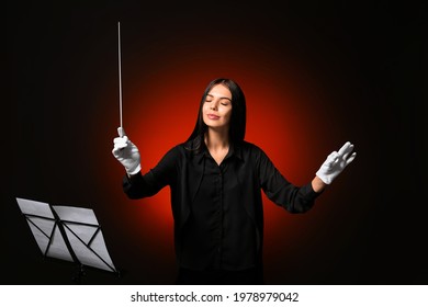 Young Female Conductor On Dark Background