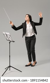 Young Female Conductor On Grey Background