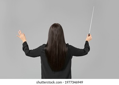 Young Female Conductor On Grey Background