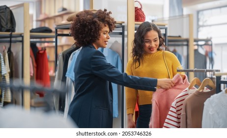 Young Female Customer Shopping in Clothing Store, Retail Sales Associate Helps with Advice. Diverse People in Fashionable Shop, Choosing Stylish Clothes, Colorful Brand with Sustainable Designs - Shutterstock ID 2053746326