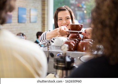 Young female customer taking coffee from barista in coffee shop - Powered by Shutterstock