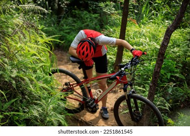 Young Female Cyclist With mountain bike on mountain trail - Powered by Shutterstock