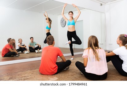 Young Female Dance Instructor Teaching Teenage Boys And Girls Of Classical Ballet Technique In Choreography Class

