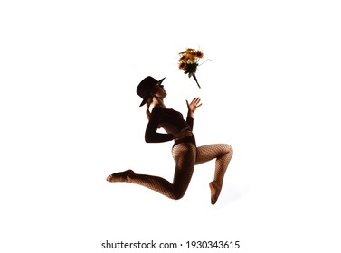 A young female dancer is seen on a stage with 
a white background behind her. She leaps up 
high and throws around a bouquet of flowers. - Powered by Shutterstock