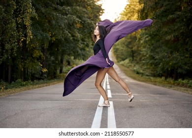 Young Female Dancing Modern Jazz Ballet Outdoors. Active Fit Ballerina In Dynamic Pose In Pointe Shoes Tiptoe. Dancer In Motion With Purple Fabric In Hands, Performing Professiobal Ballet Alone