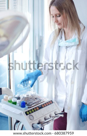 Young female dentist working in dental office.