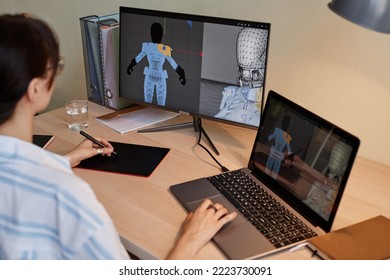 Young female designer building digital 3D models for videogame characters at workplace and using pen tablet - Shutterstock ID 2223730091