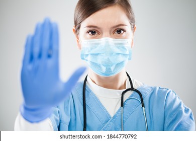 Young female doctor hand gesturing STOP, Coronavirus COVID-19 disease global pandemic outbreak, keep social physical distance, do not enter. Quarantine isolation, safety measures against virus spread