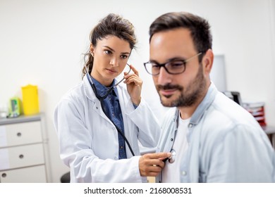 Young female doctor listen to male patient heart chest with stethoscope at clinic meeting. Woman GP checkup examine man client with phonendoscope. healthcare concept. - Powered by Shutterstock