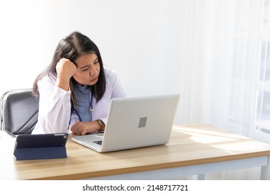 Young Female Doctor Looking At Laptop Computer And Tired From Work